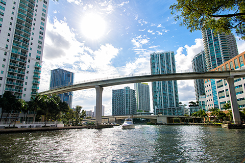 This is a stock photo from Shutterstock. This is a photo taken on the Miami River. The river is in the foreground, and high-rise apartment buildings are in the background.