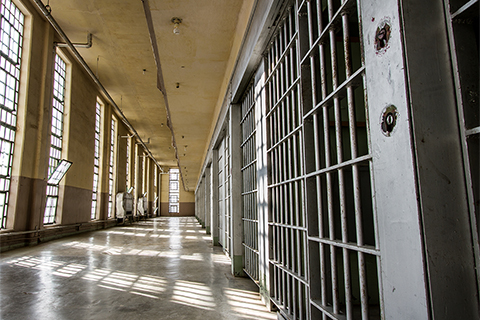 Sunlight filtering through prison bars in an incarceration facility. 